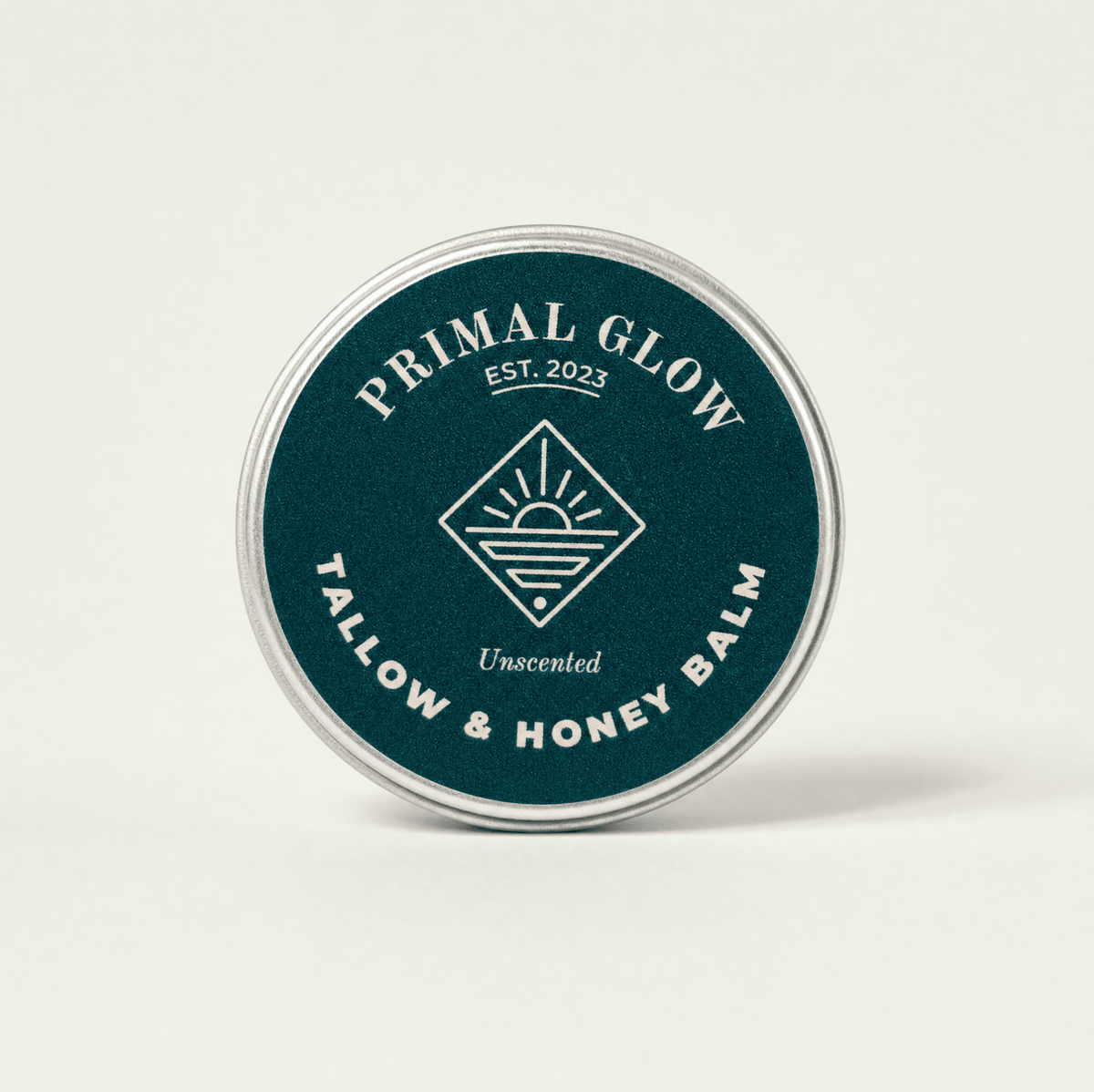 Bovenaanzicht van de Primal Glow tallow en honing hydraterende balsem van 15 ml met zichtbaar logo.